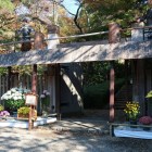 山麓の信長公居館に続く冠木門（模擬）。菊花展開催中のため菊人形の門番も