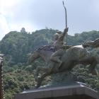 若き日の織田信長像越しに天守を望む