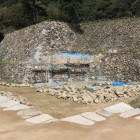 楯蔵跡より巻石垣復元工事を見る
