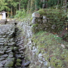 復元の土塀と門の西側より現状の様子を見る