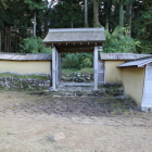 復元の土塀と門を屋敷跡側から見る