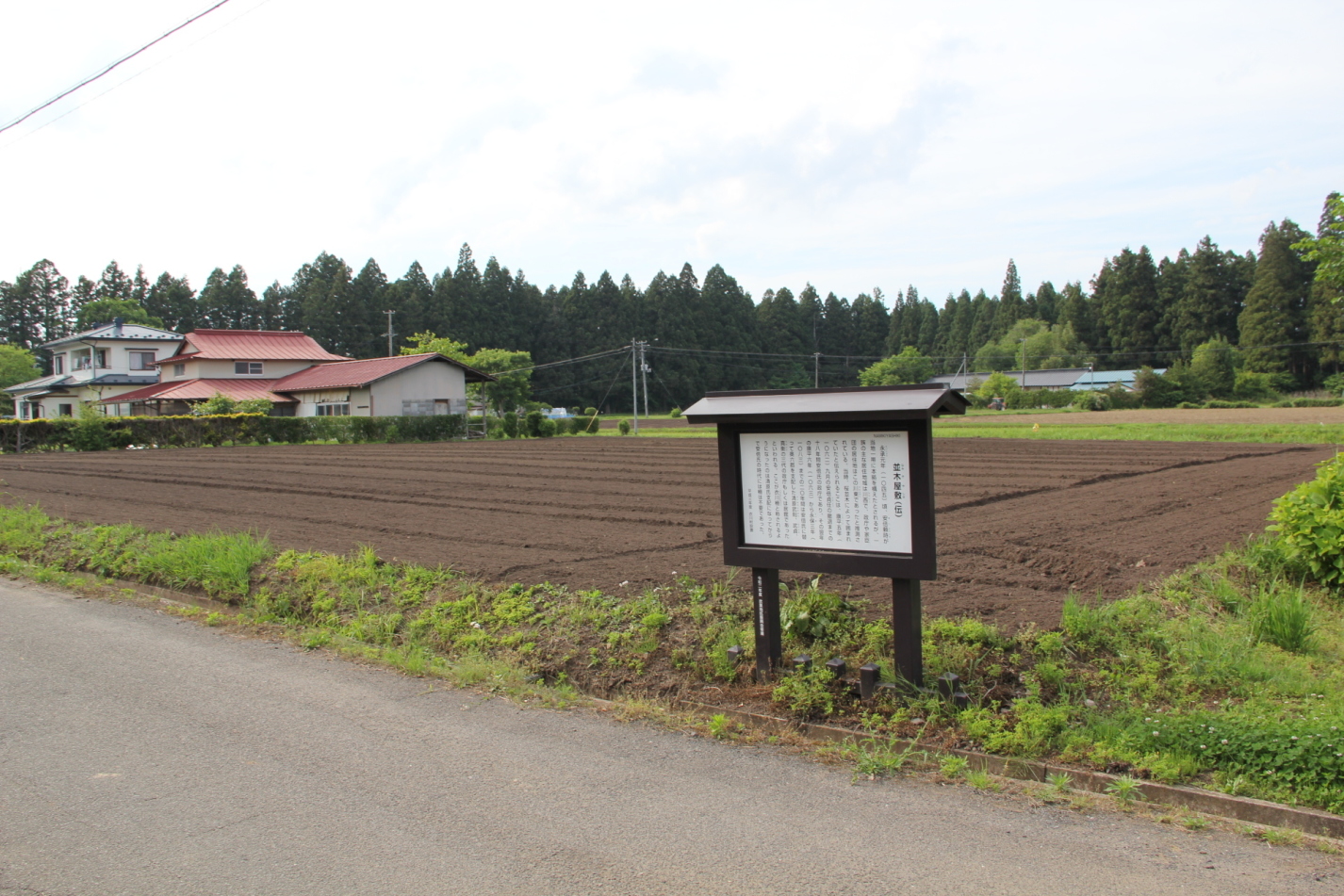 道路沿いの案内板、手前に路駐