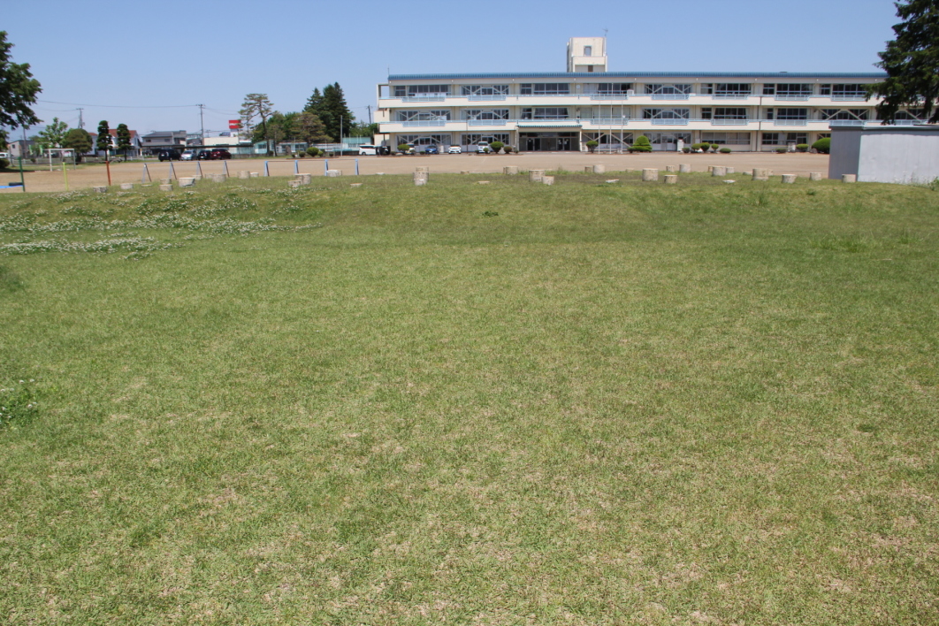 政庁正殿跡地面表示、奥は徳田小学校