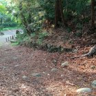 本郭から二ノ郭を望む(坂に石積み・奥に飯野平城の碑)