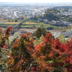 展望所から紅葉越しに天竜川の鉄橋、遠く浜松アクトタワーが見える